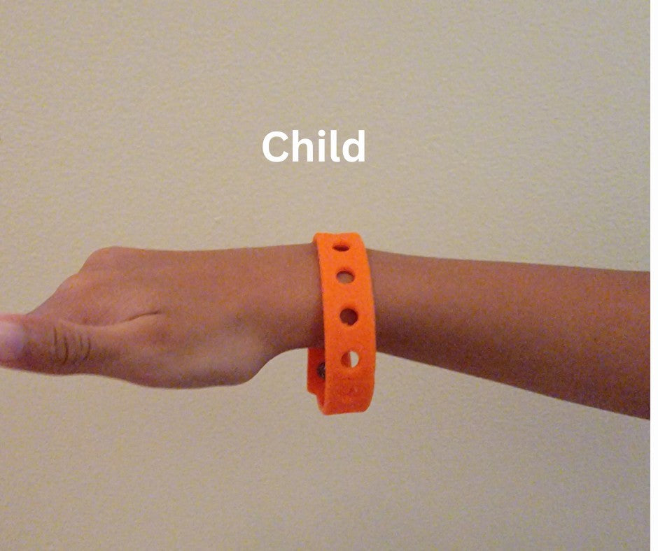 Orange croc jibbitz charm bracelet worn on wrist with adjustable snap closure, child wearing silicone bracelet.